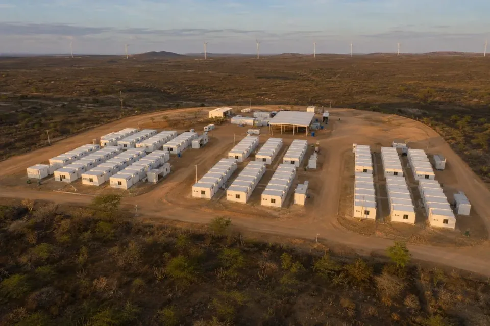 Canteiro de containers modulares Tecnomod visto de cima, com parque eólico ao fundo