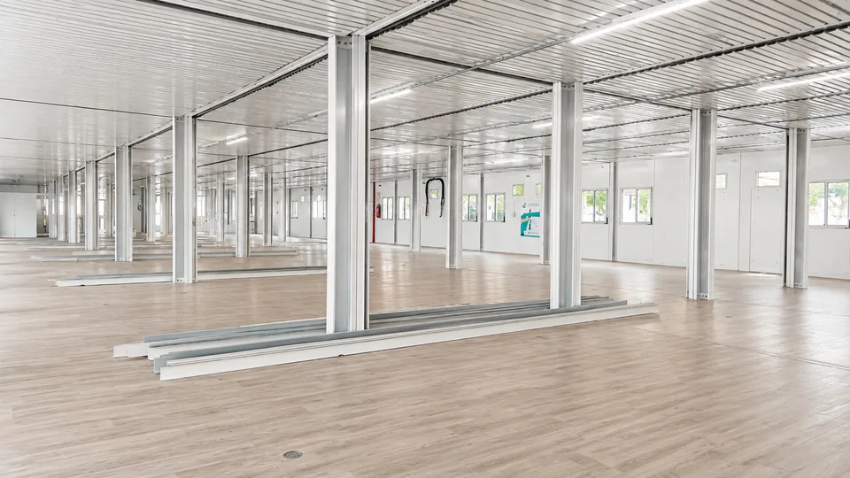 Interior de complexo modular concluído, com piso vinílico, forro e iluminação entregues