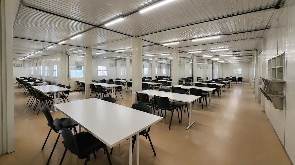 Refeitório modular de grande área com dezenas de mesas, formado por módulos acoplados em vão único
